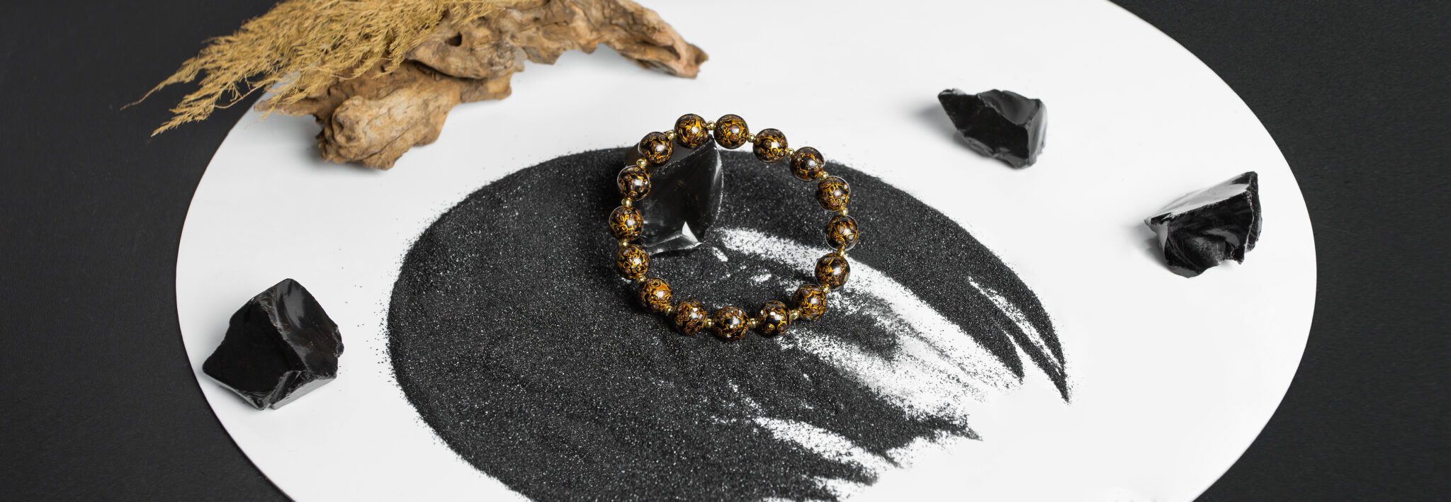 Handcrafted black Cloisonné bracelet from Moke, inspired by ancient Asian craftsmanship and adorned with intricate golden patterns. Set against obsidian stones and ink-like textures, this modern accessory embodies strength, elegance, and timeless oriental aesthetics.