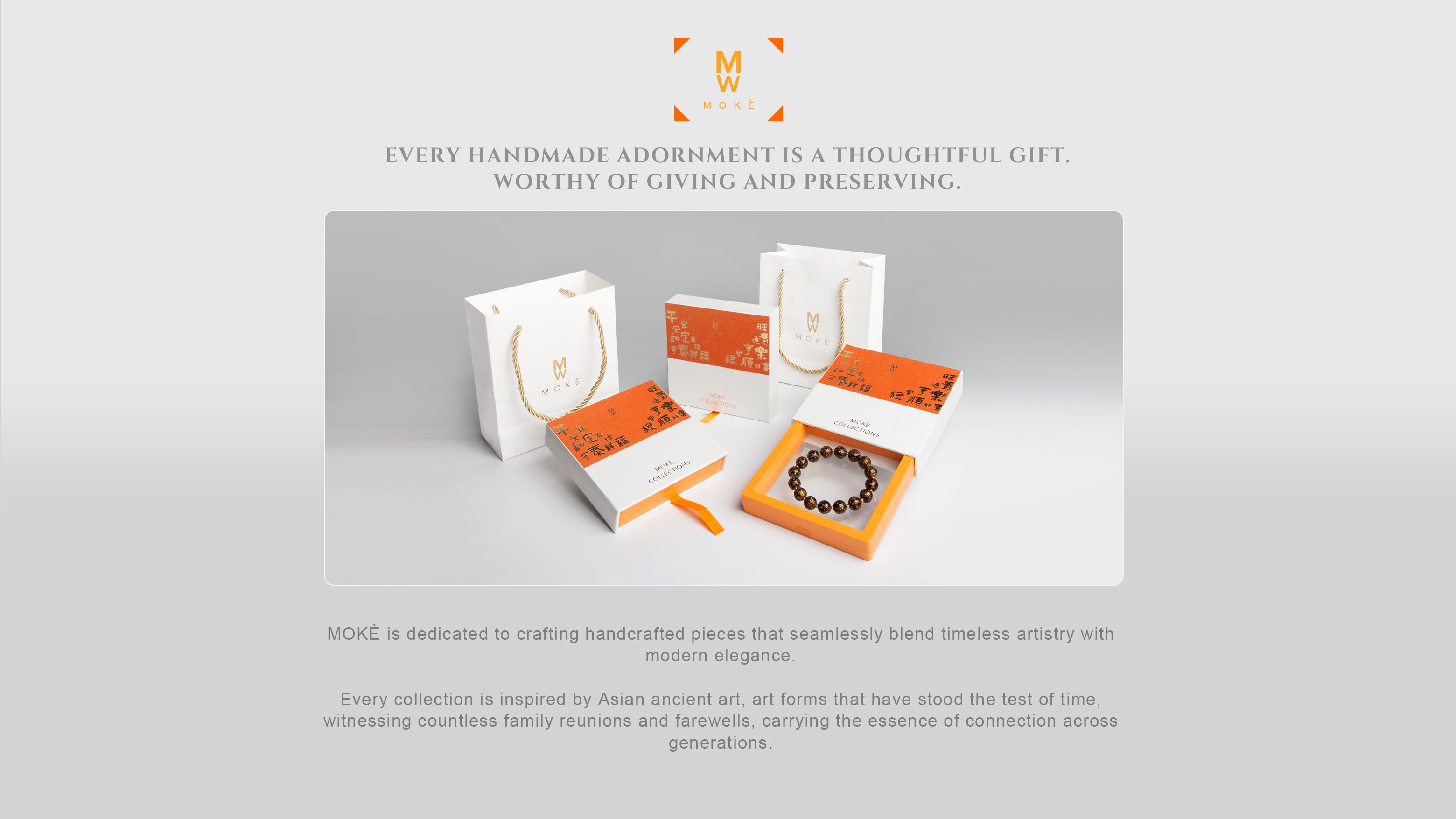 A branded display on a light gray background featuring the MOKÈ logo above the headline “Every handmade adornment is a thoughtful gift. Worthy of giving and preserving.” Centered is a photo of white and orange packaging: two white paper gift bags with gold rope handles, two white slide-out gift boxes with bright orange lids printed with Chinese calligraphy, and an open box revealing a dark beaded bracelet nestled in an orange tray. Below the image, gray text reads that MOKÈ crafts pieces blending timeless artistry with modern elegance, inspired by ancient Asian art and family traditions.